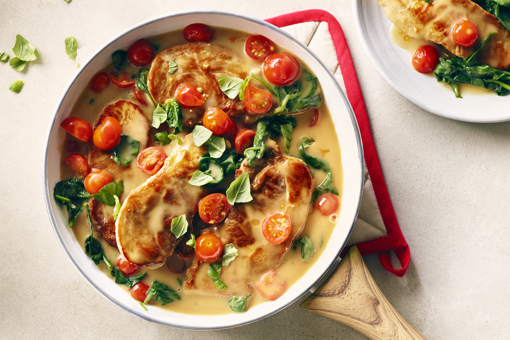 Côtelettes de porc en sauce avec épinards et tomates